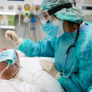 Nurse is comforting a covid patient at the ICU